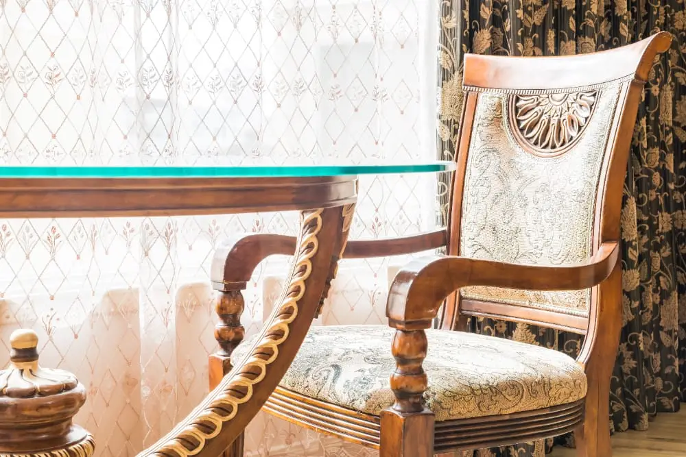 Chaise ancienne en bois tourné et tissu brodé près d'une fenêtre